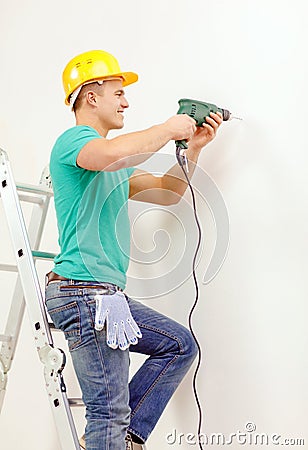 Man with electric drill making hole in wall Stock Photo