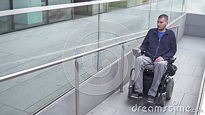 Man on electric wheelchair driving on a street. Accessibility concept Stock Photo