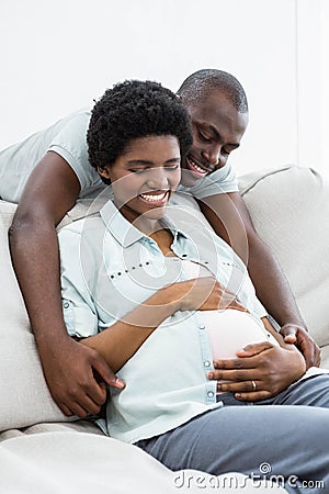 Man embracing pregnant woman from behind Stock Photo