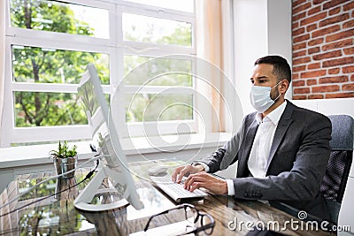 Man Employee In Office Wearing Face Mask Working Stock Photo