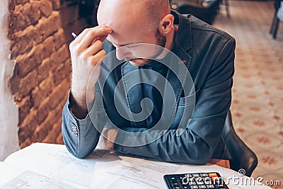 Man engineer designer architect reading drawings at table in cafe Stock Photo