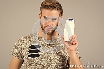 Man enjoy freshness after washing hair with shampoo. Guy with hairstyle holds bottle shampoo, copy space. Hair care and Stock Photo