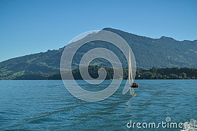 Man enjoying his time on small sailboat on Lake Lucerne close to Kussnacht am Rigi in Switzerland Editorial Stock Photo