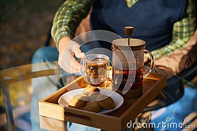 Man enjoys cup of tea on veranda of country house Stock Photo