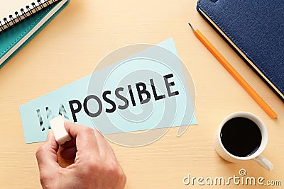 man erasing card with the text impossible, cutting the word im so it written possible. success and challenge concept Stock Photo