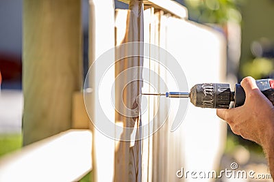 Man erecting a wooden fence outdoors Stock Photo