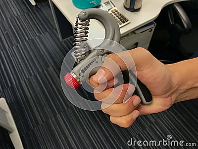Man exercise his hand by strength handgrip to prevent office syndrome Stock Photo