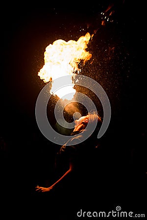 Man exhaling fire on a black background. Fire show Stock Photo