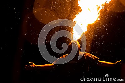 Man exhaling fire on a black background. Fire show Stock Photo