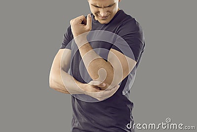 Man experiences pain in elbow joint, which may be symptom of osteoporosis, bone arthritis or gout. Stock Photo