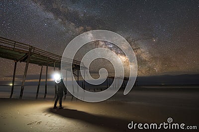 Man exploring a damaged pier at night Stock Photo