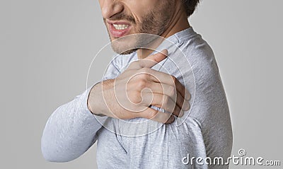 Man face expresses pain. Guy has Inflammation in shoulder Stock Photo