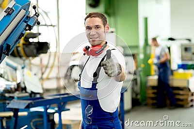 Man in factory with thumb up Stock Photo