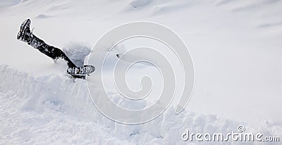 Man is falling headfirst into deep snow. Concept of winterly slippery conditions. Stock Photo