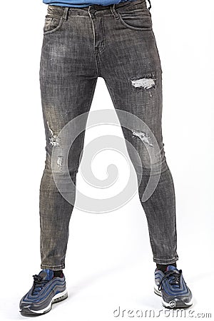 a man in fashionable black ripped jeans on a white background Stock Photo