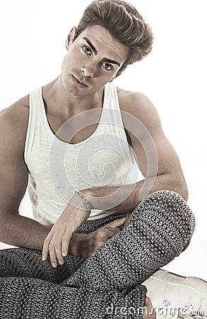 Man fashionable hair style sitting leg crossed head tilted Stock Photo