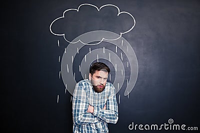 Man feeling cold standing under rain drawn on chalkboard background Stock Photo