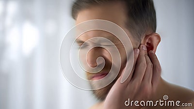 Man feels pain in middle ear, meningitis and hearing loss, inflammation, closeup Stock Photo