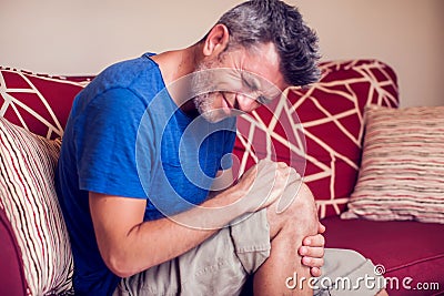 Man feels strong knee pain. People, medicine and healtcare concept Stock Photo