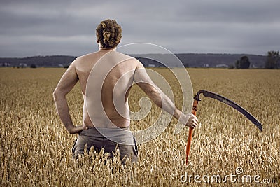 Man in field with scythe Stock Photo