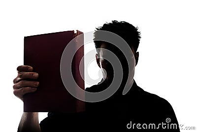 Man figure in silhouette showing a book Stock Photo