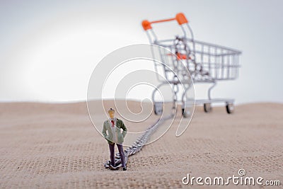 Man figurine attached to a Shopping cart Stock Photo