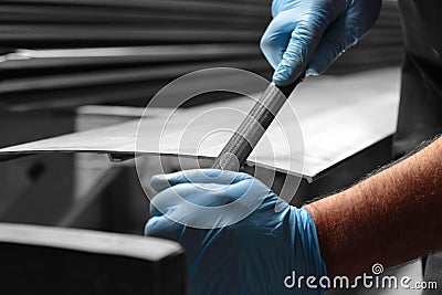 Man filing deburring a metal panel with a file Stock Photo