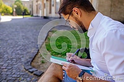 Man Fill Out Application Form. Businessman Sits Near Outdoor And Writes On Paper Forms Stock Photo