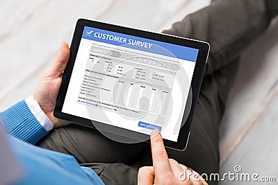 Man filling customer survey form on tablet computer Stock Photo