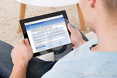 Man Filling Survey Form Online On Digital Tablet At Home Stock Photo