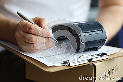 Man fills in home delivery mail document on box Stock Photo