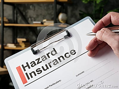 The man fills out the Hazard insurance form. Stock Photo