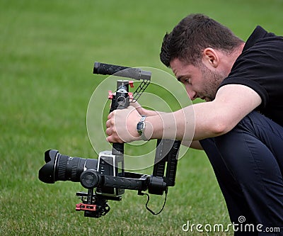 Man filming action professionally at agricultural show demonstration. Editorial Stock Photo