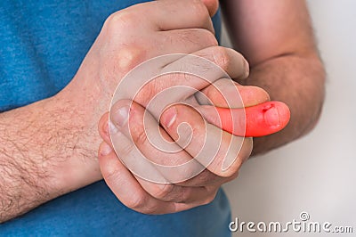 Man with finger pain is holding his aching finger Stock Photo