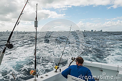 A man in a fishing boat in a stormy ocean with a view of the coast of Miami. Stock Photo