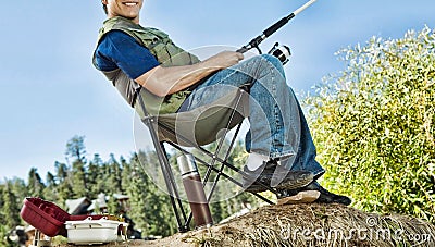 Man Fishing in Collapsible Chair Stock Photo