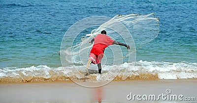 MAN FISHING WITH NETWORK AT SEA Editorial Stock Photo