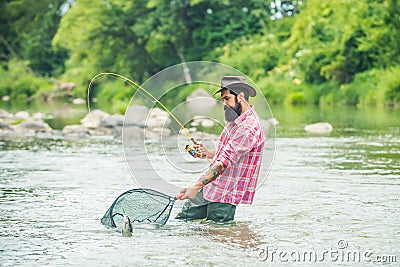 Man fishing and relaxing while enjoying hobby. Fish on the hook. Fisherman and trout. Summer holidays and people concept Stock Photo