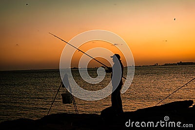 Man fishing with fishing rod in sunset, silhouette. Editorial Stock Photo