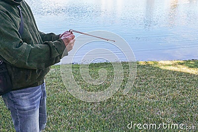 a man is standing by the water with a fishing pole Stock Photo