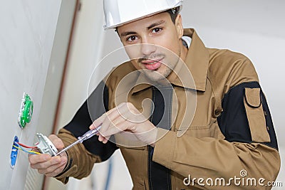 Man fitting electrical outlet in bathroom Stock Photo