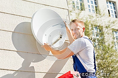 Man Fitting TV Satellite Dish Stock Photo