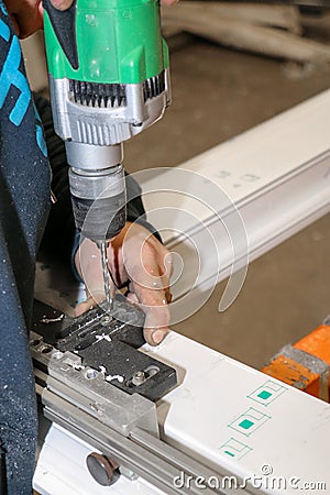 A man fixes an element for the realization of PVC window frames in a carpentry Stock Photo