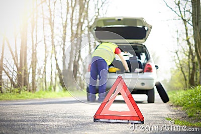 Man fixing a car problem after vehicle breakdown on the road Stock Photo