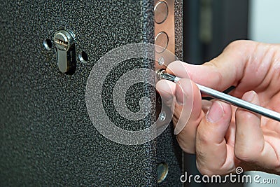 Man fixing the door with screwdriver. Door lock repair Stock Photo