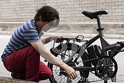 Man fixing electric bike on the side of the road Stock Photo