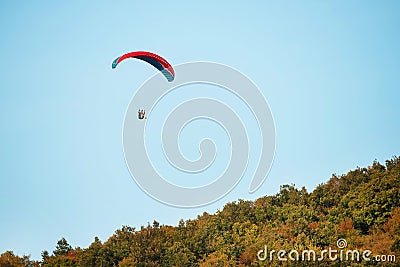 A man flies in his paraglider near Siria Medieval Fortress in Arad County, Romania. Stock Photo