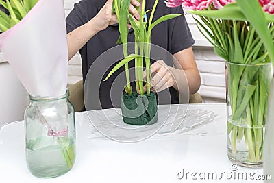 A man florist collects a bouquet of tulips using a sponge Stock Photo