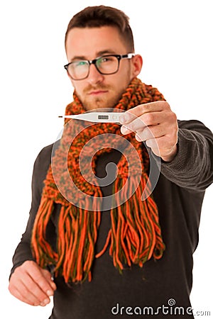 Man with flu and fever wrapped in scarf holding thermometer. Stock Photo