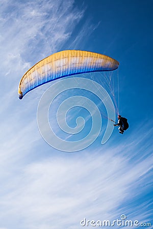 Man flying yellow and blue parasail Stock Photo